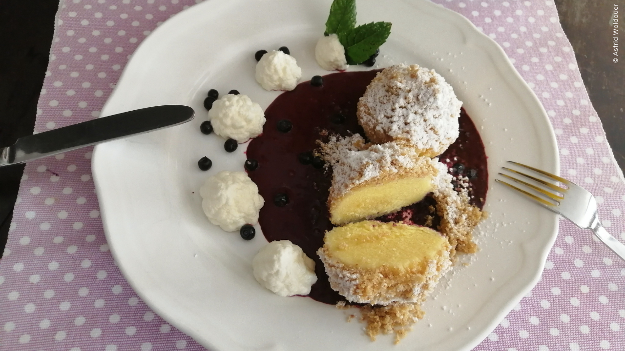 Topfenknödel auf Schwarzbeerspiegel
